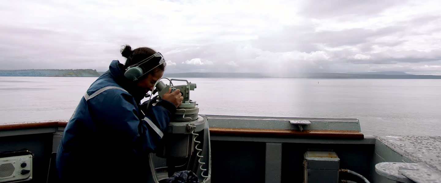 A United States Navy Boatswain’s Mate stands the lookout watch aboard the USS Carney aircraft carrier.