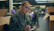 A Navy Sailor takes inventory of essential supplies in a ship's storage area.