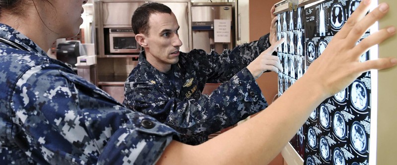 Two Navy Hosptial Corpsmen examine x-rays