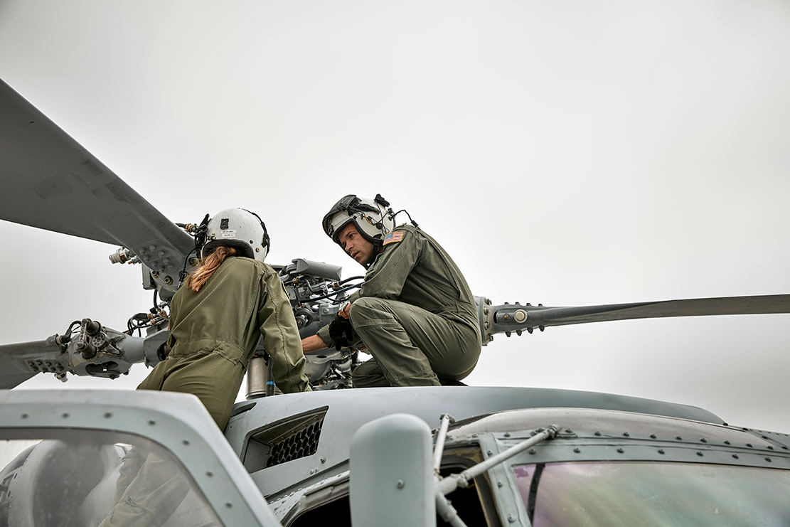 Aviator Aric McGee and a colleague discuss helicopter maintenance 