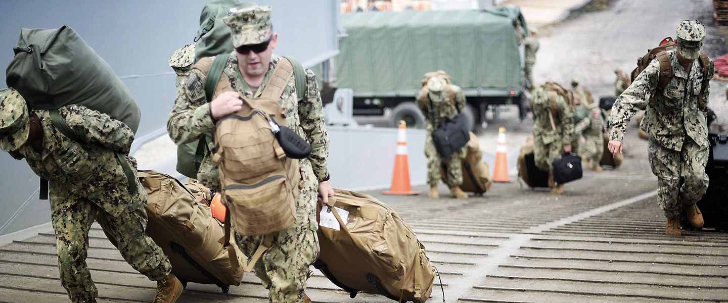 Navy Sailors in uniform preparing to board a ship.