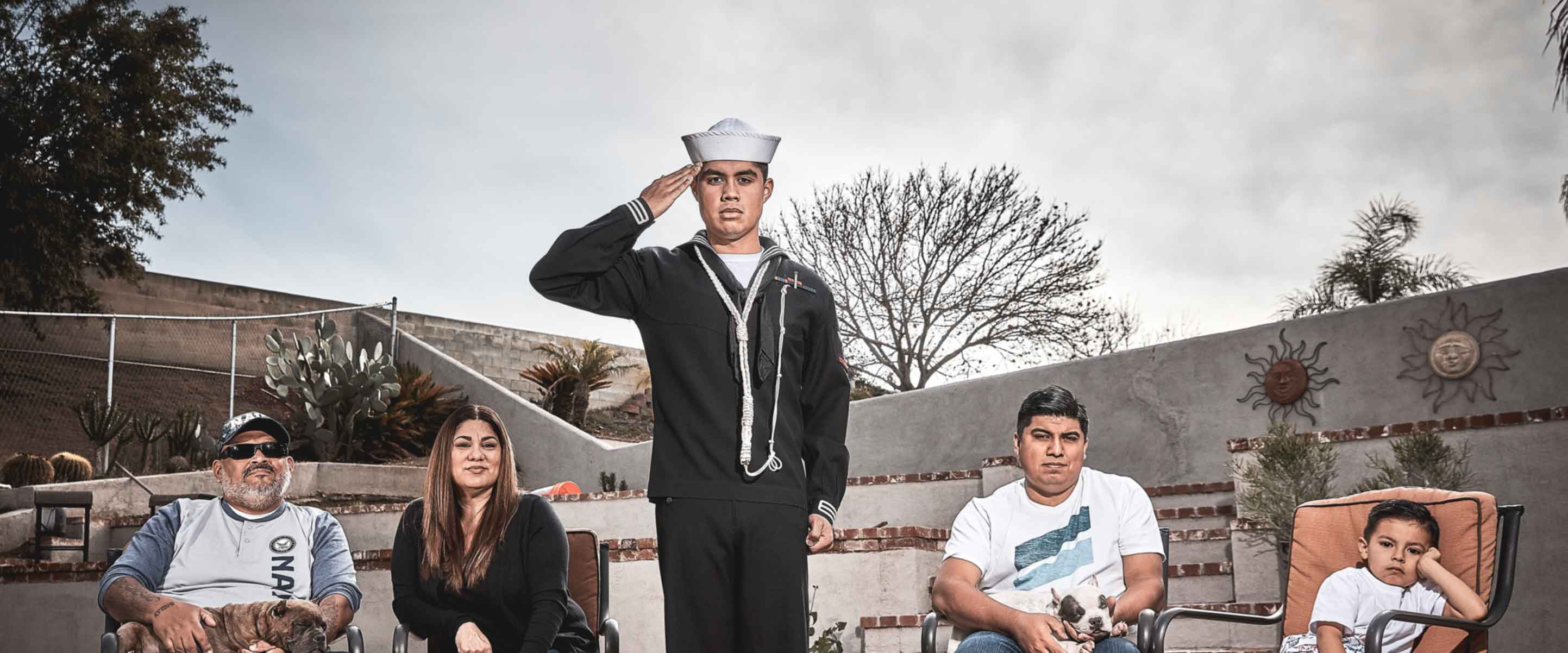 U.S. Navy Sailor Michael Benitez poses with his family in full Navy uniform