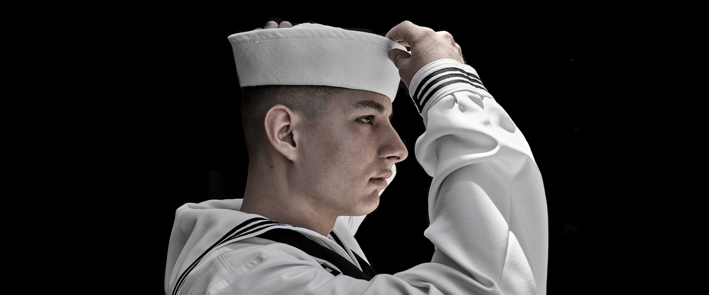 U.S. Navy Sailor Thomas Schwab adjusts his cover in full uniform