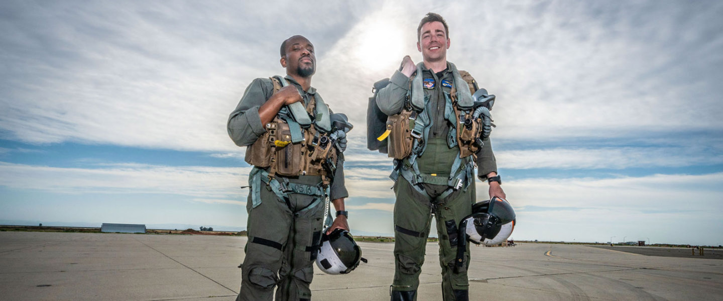 YouTuber uravgconsumer poses with a navy fighter pilot after a flight experience on an f18
