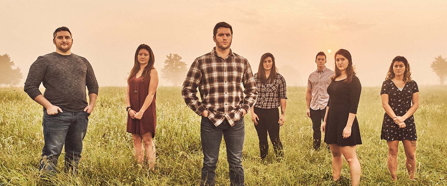 Colten Hubbard poses for a photo with his six siblings in a field in his hometown of Hermann Missouri