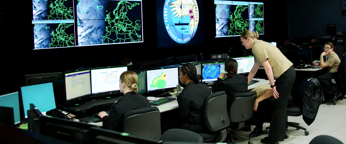 A team of aerographer mates monitor weather radar equipment and analyze weather and ocean data