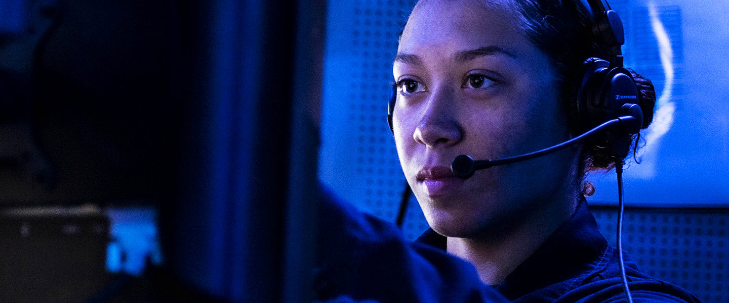 A female navy cryptologic technician analyzes encrypted electronic communications aboard a navy aircraft carrier