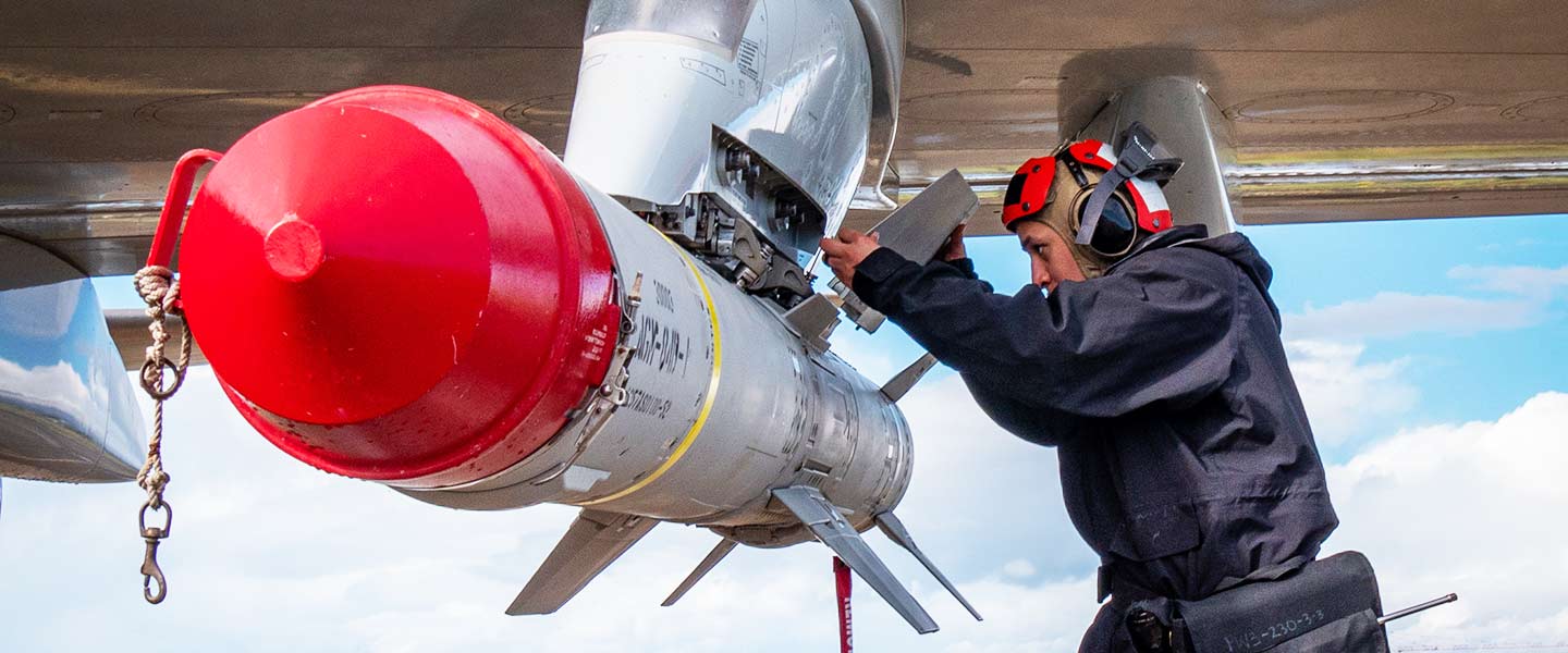A United States Navy Aviation Ordnanceman installs the fin of a missile onboard a P-8A Poseidon maritime patrol aircraft.