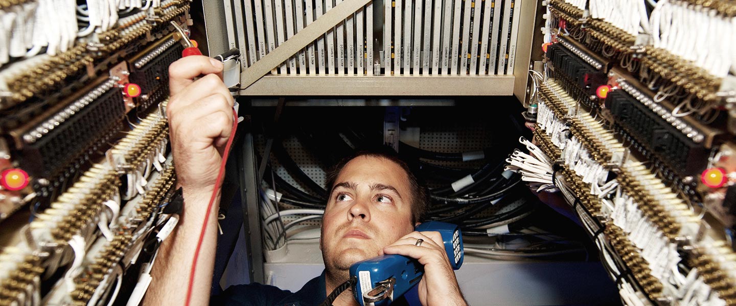 A United States Navy Interior Communications Electrician troubleshoots a communications system aboard the USS James E. Williams destroyer ship.