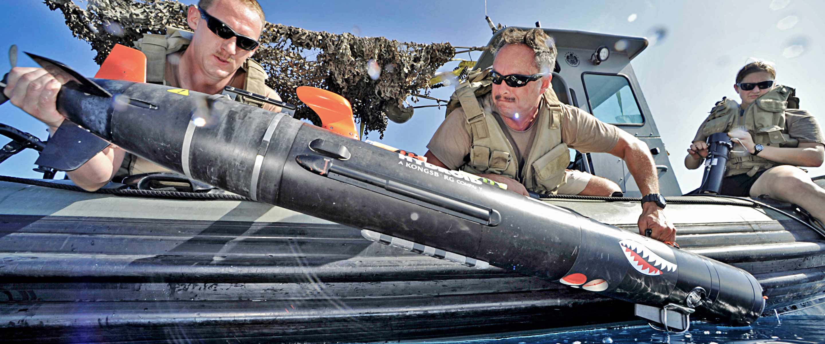 Navy oceanographers check an underwater drone for data and information