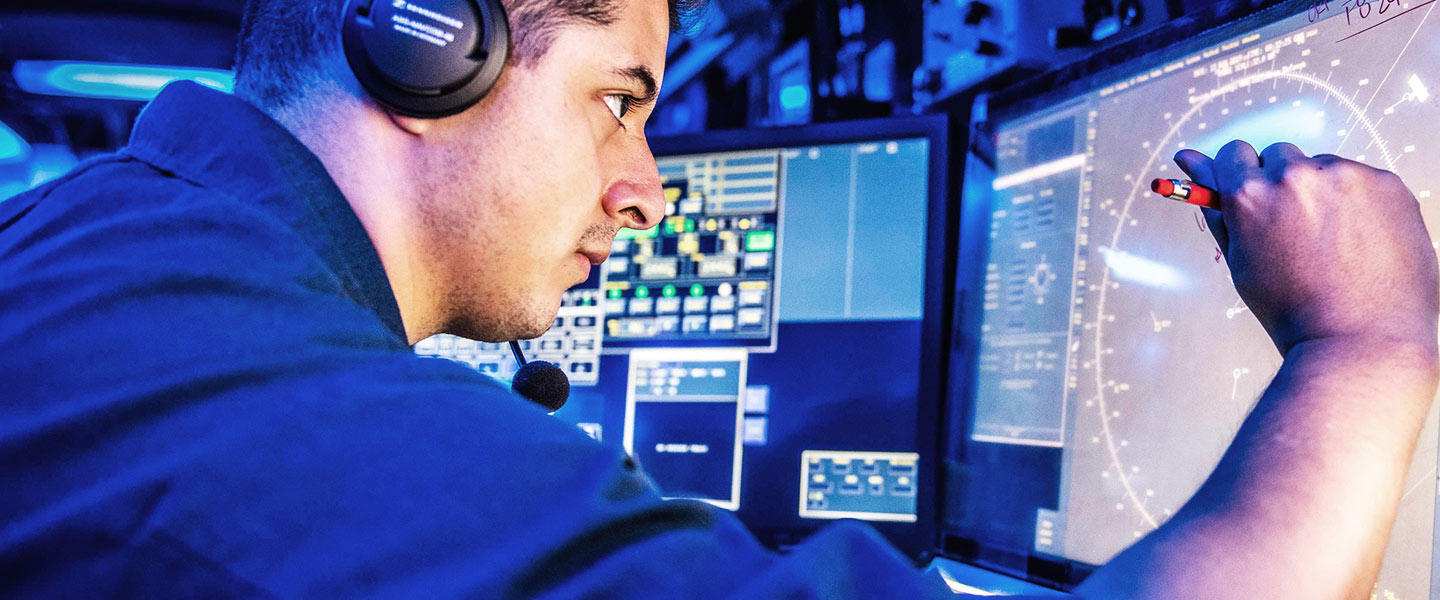 A United States Navy Operations Specialist stands watch during a strike operation exercise aboard the USS Milius guided missile destroyer.