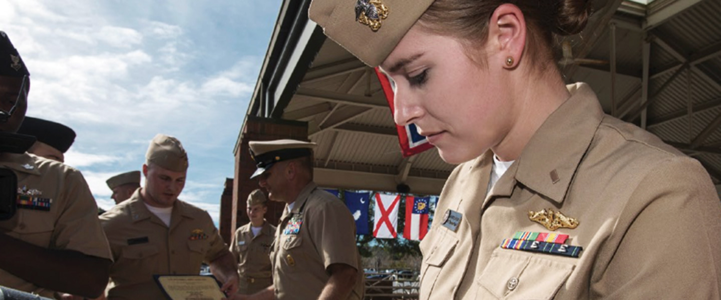 United States Navy Reactors Engineer celebrate after receiving her submarine officer warfare insignia at Naval Submarine Base Kings Bay.