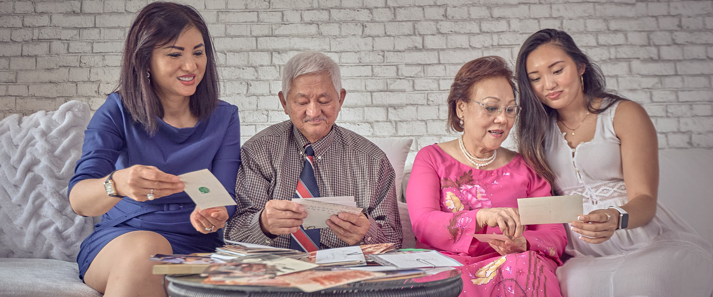 Diana Tran-Yu, a United States Navy Lieutenant Commander and Health Care Administrator, looks at family photographs with her parents and her daughter, a Navy Intelligence Specialist.