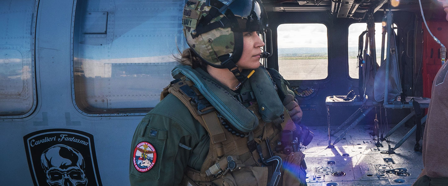 A United States Navy Aircrewman (Helicopter), left, briefs an Aviation Machinist’s Mate post-flight.