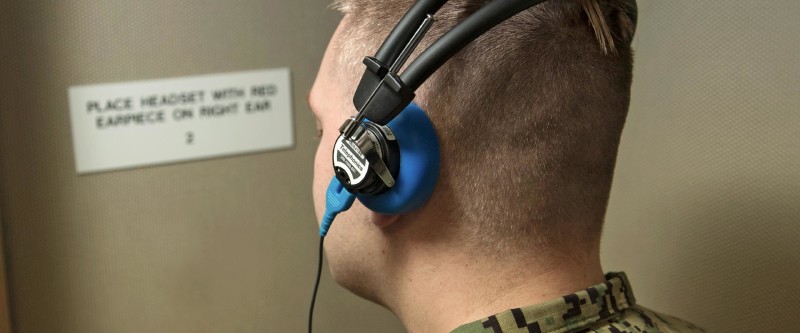 A Navy Sailor's hearing is tested by an Audiologist