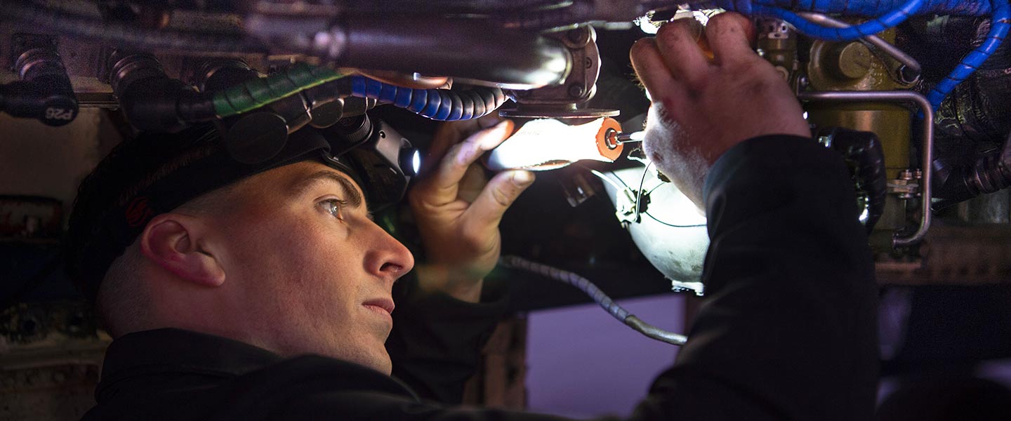 A United States Navy Aviation Electrician’s Mate replaces the engine bleed air element on a Blue Angel F/A-18 Hornet fighter jet.