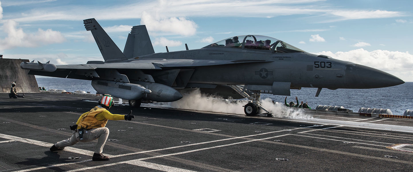 A United States Navy Catapult Officer signals the pilot of an EA-18G Growler to take off from the flight deck of the aircraft carrier USS Theodore Roosevelt.