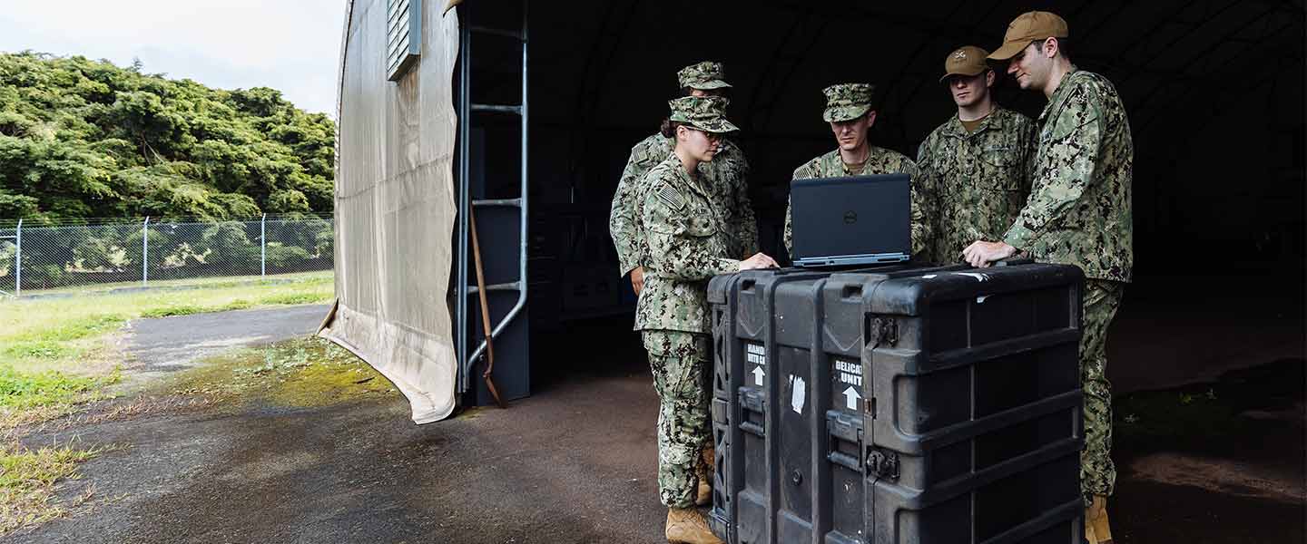 A Navy Cryptologic Warfare Officer works with their team.