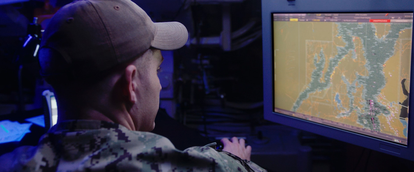 A United States Navy Electronics Technician Navigation reviews navigation data aboard a submarine.