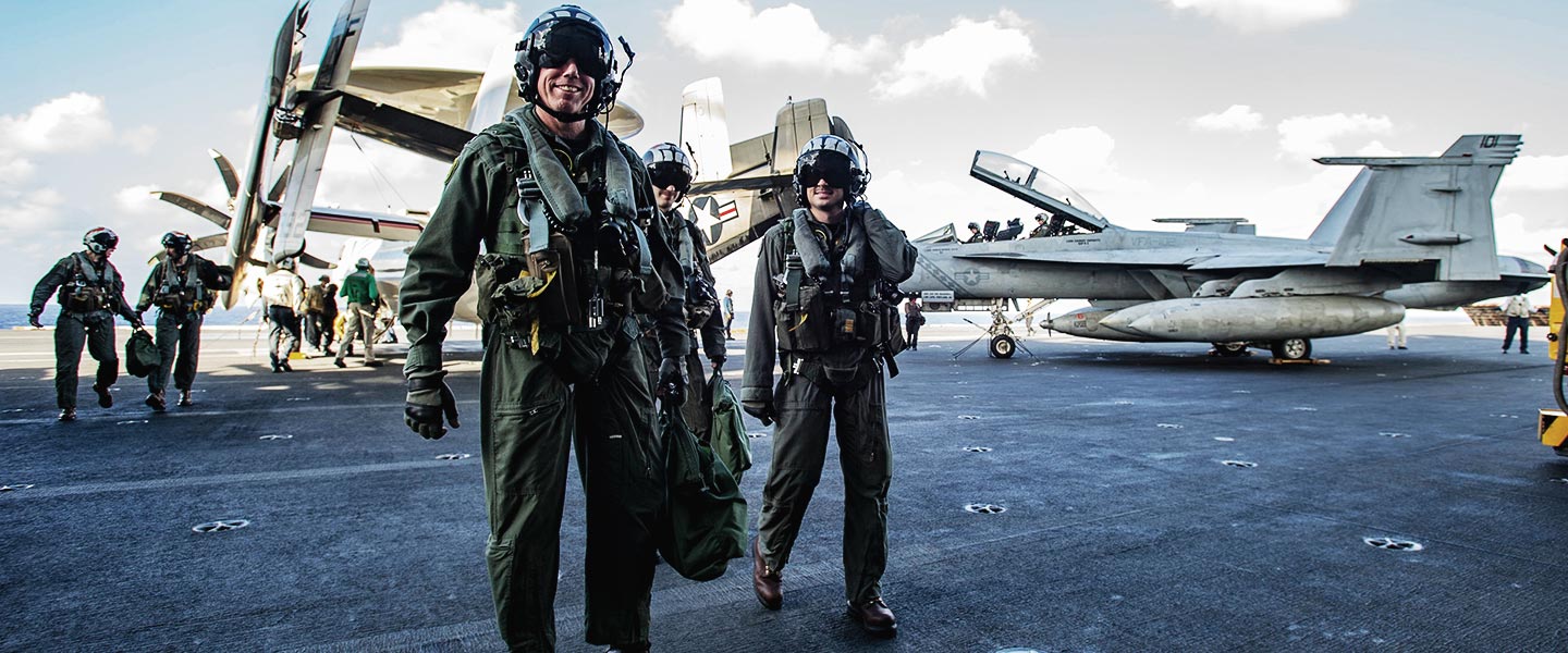 A United States Navy Rear Admiral Fixed Wing Pilot departs an E-2D Hawkeye on the flight deck of the USS Ronald Reagan.