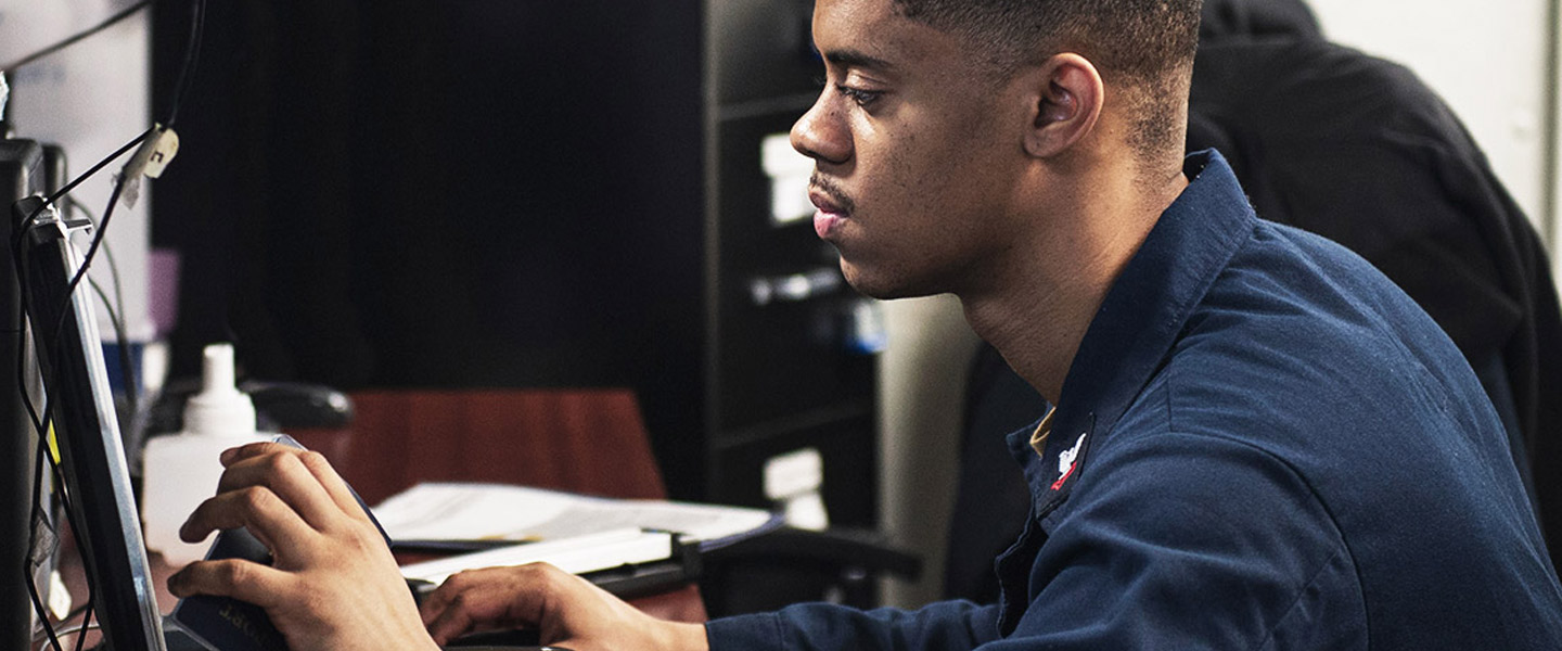 Personnel Specialist 2nd Class Cameron Green creates a new common access card aboard the aircraft carrier USS Dwight D. Eisenhower.