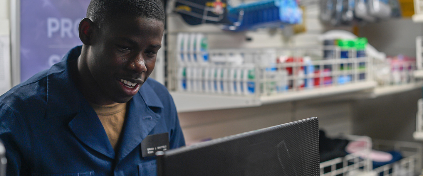 U.S. Navy Retail Services Specialist Seaman Brian Whitfield, from Atlanta, mans the register in the ship’s store aboard the Arleigh Burke-class guided-missile destroyer USS Pinckney.