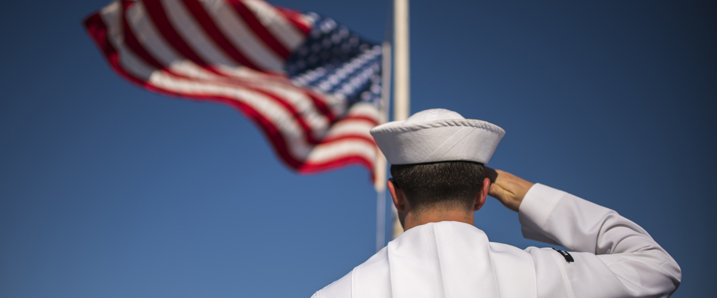 A United States Navy Sailor salutes the American flag