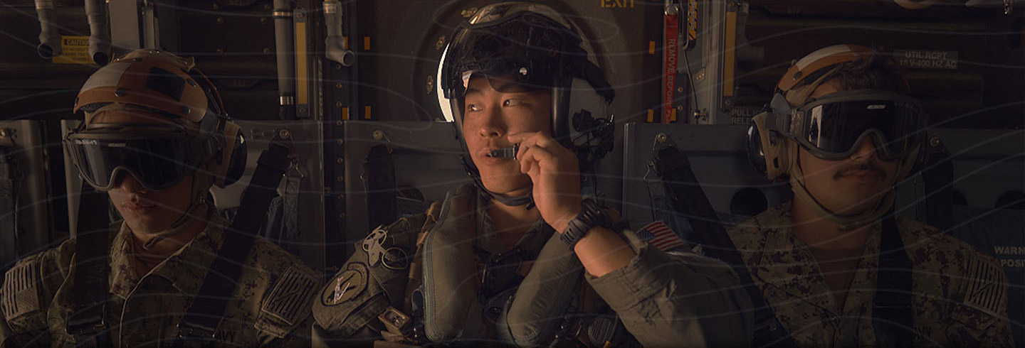 United States Navy Sailors await take-off on a Navy cargo plane, using headset microphones to communicate with one another.