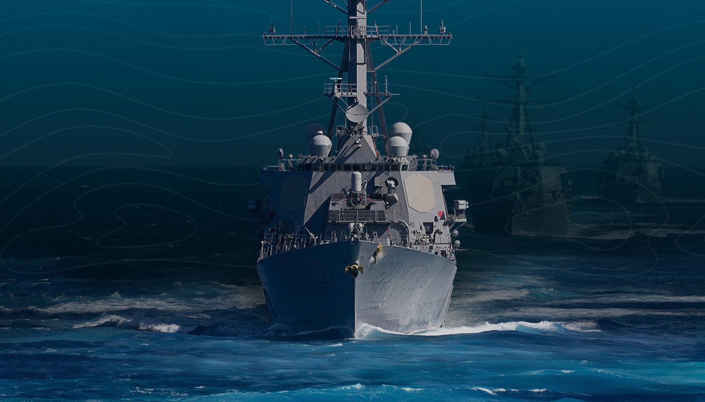 A United States Navy ship moves through open seas as part of a fleet training exercise.