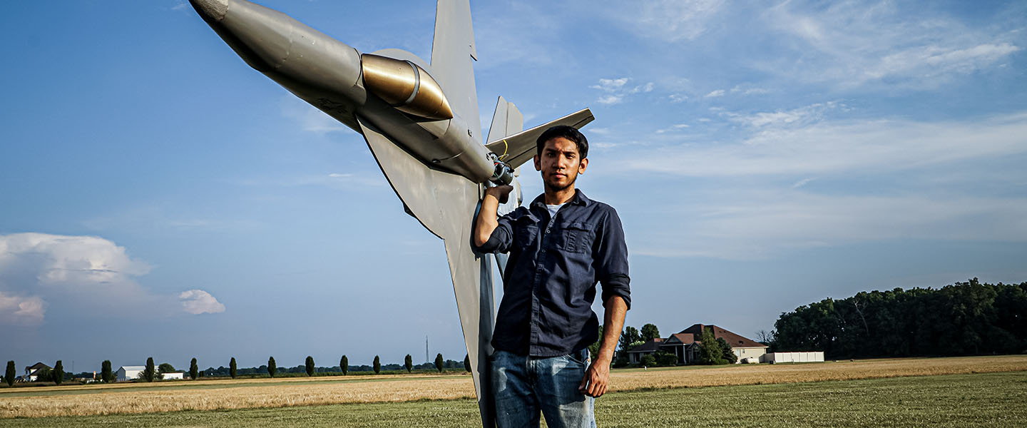 YouTube Creator Peter Sripol displays a large model F-18 as part of the US Navy's Sailor VS series.