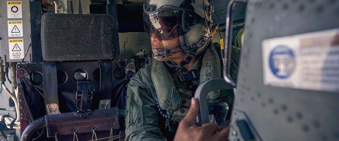 United States Navy Aircrewman Esmelin Villar prepares for takeoff in the back of an MH-60 Romeo helicopter.