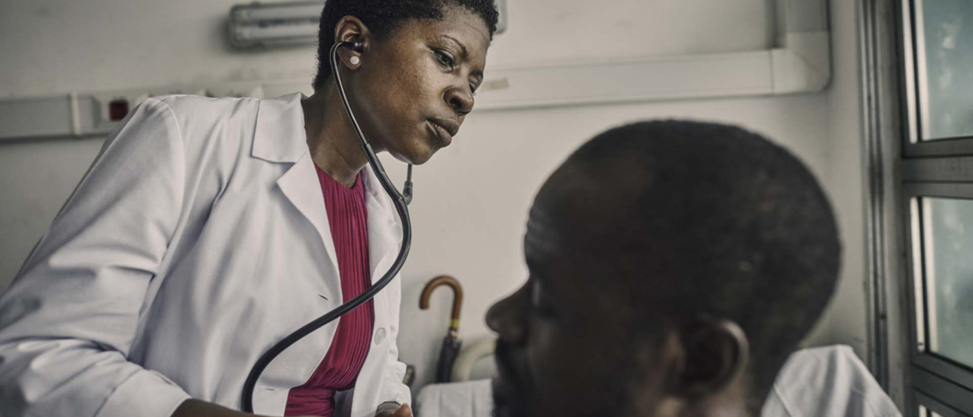 Navy doctor carefully examining a patient, listening to their chest with a stethoscope for diagnosis.