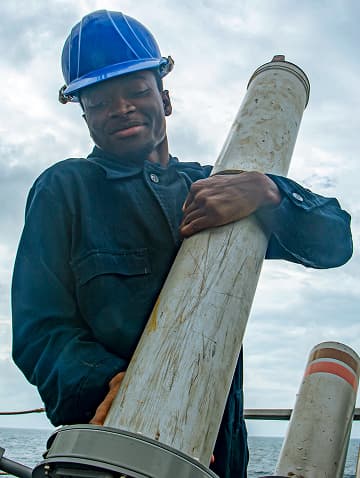 A U.S. Navy Enlisted Sailor is handling ammunition aboard a ship.