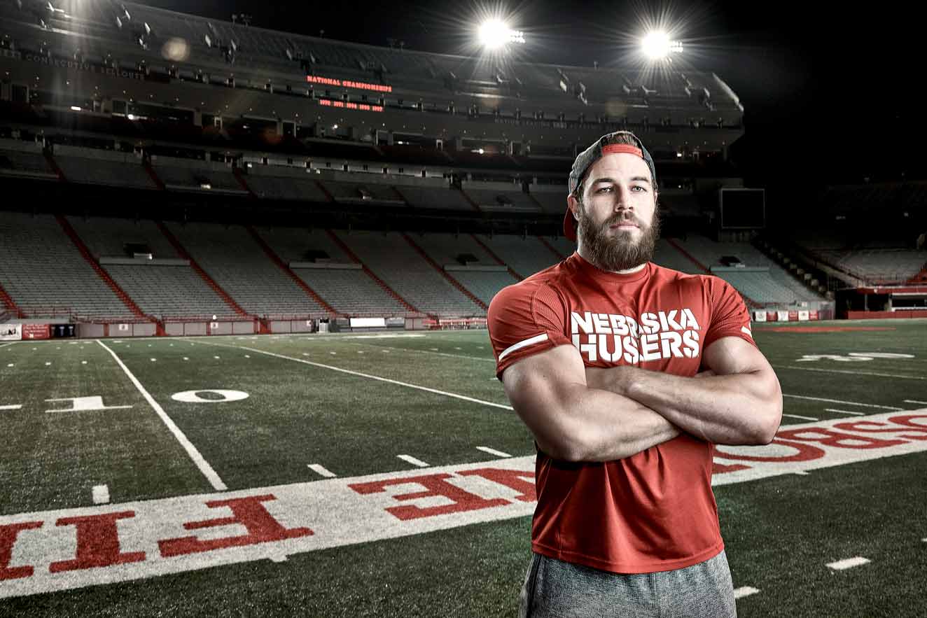 Football player and former Navy Seal Damian Jackson stands in an empty Nebraska Cornhuskers stadium under the lights at night