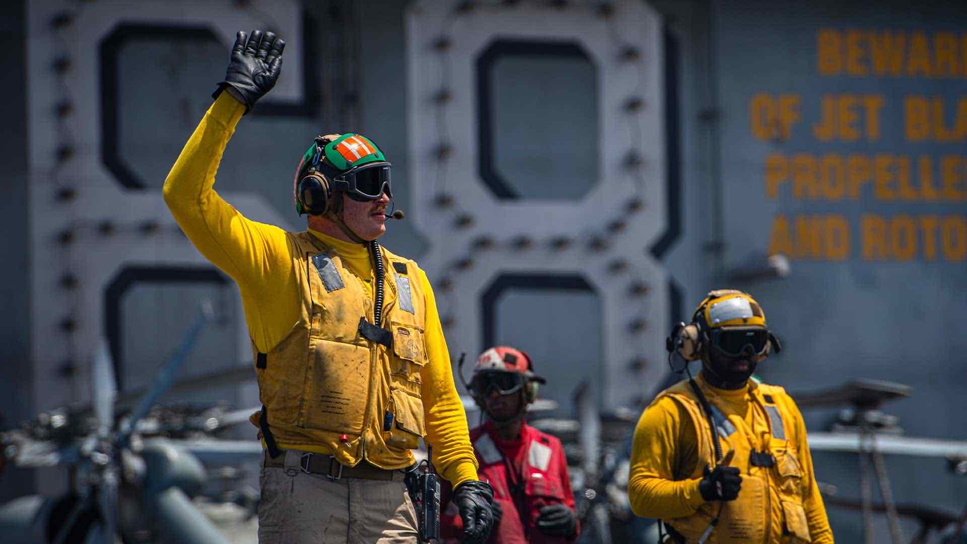 A U.S. Navy Sailor directs an aircraft on the flight deck of the aircraft carrier USS Nimitz (CVN 68).