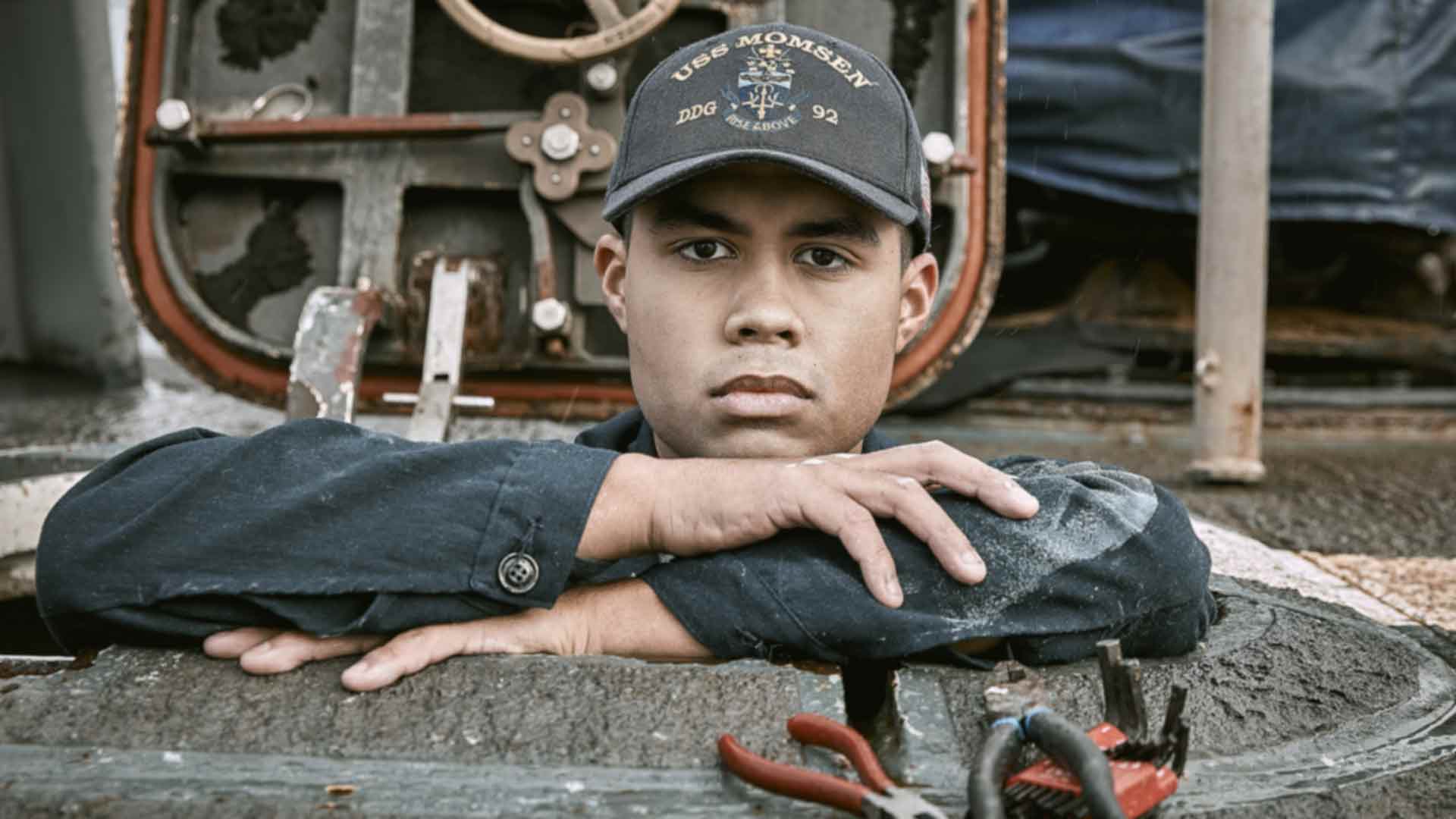 US Navy Boatswain Mate Michael Benitez poses for a photo aboard a US Navy aircraft carrier
