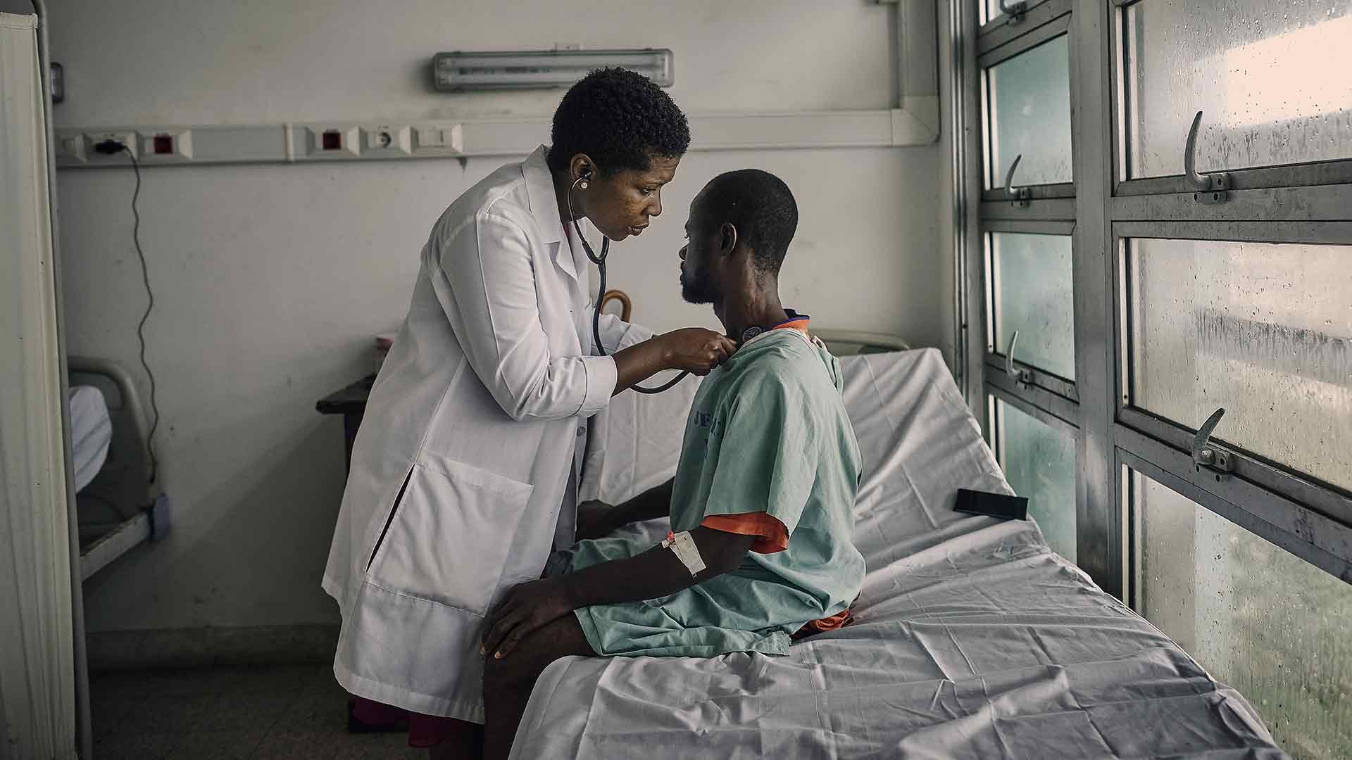 Navy Infectious disease doctor Nehkonti treats a patient in a hospital in Monrovia, Liberia