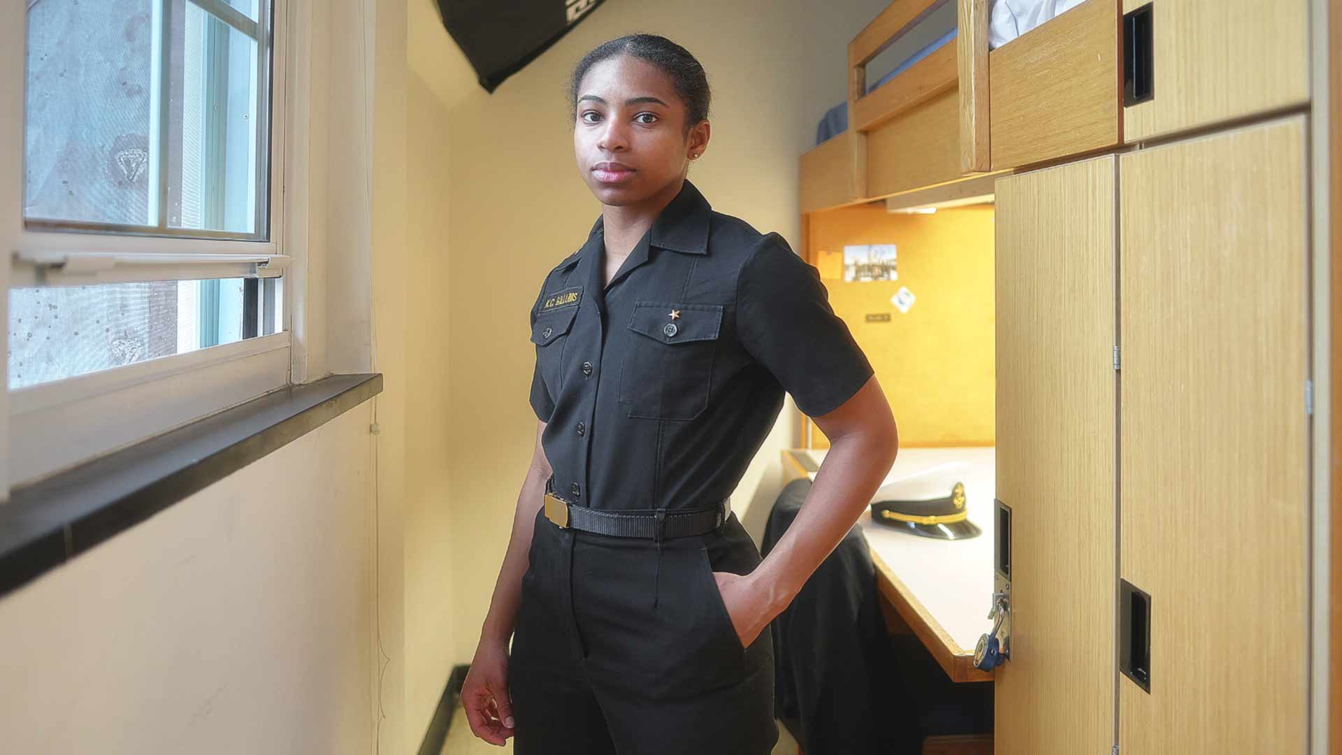 Midshipman Kaylah Gillums stands in her U.S. Naval Academy dorm.