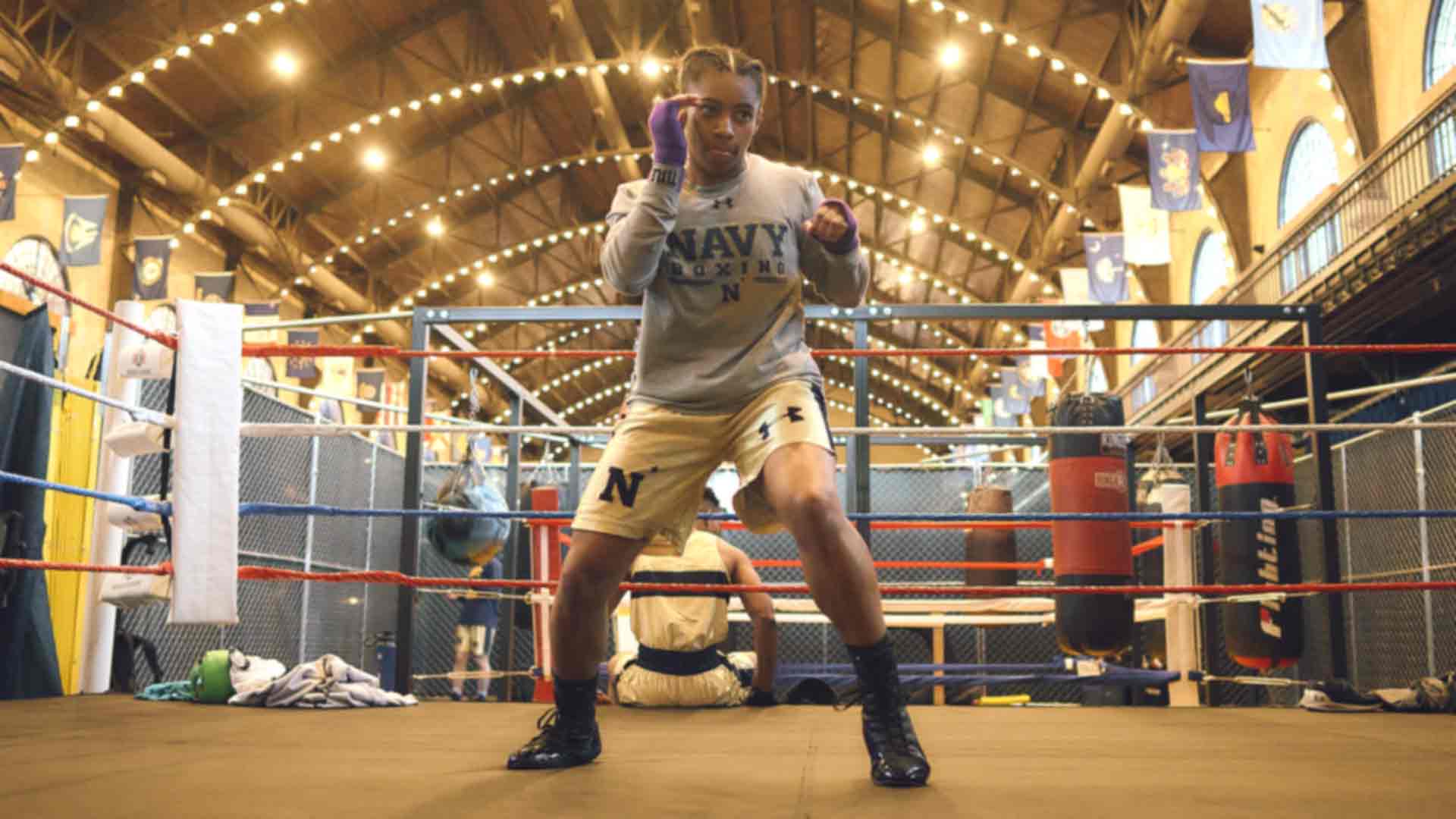 US Naval Academy Midshipman Kaylah Gillums shadow boxes in a Navy Boxing training shirt and shorts.