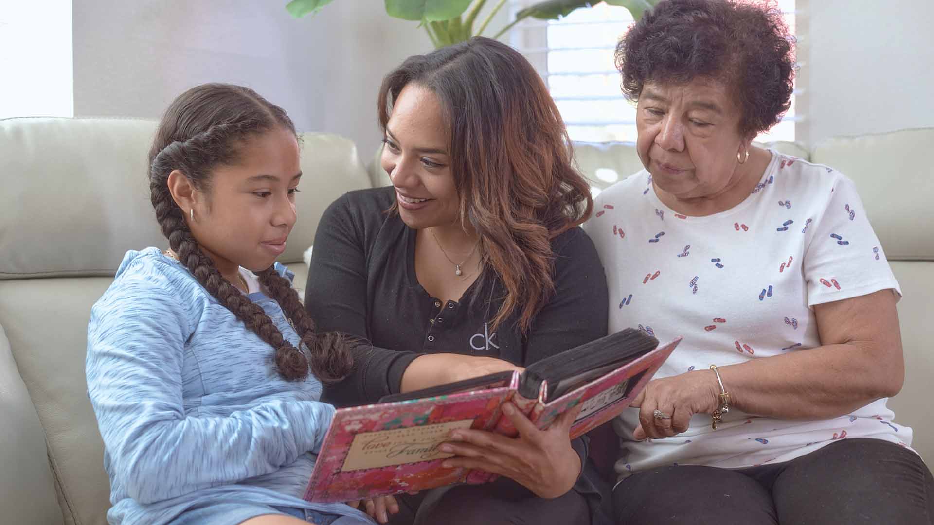 Looking through family photos, Ana Monterrosa enjoys family time with her mother and daughter.