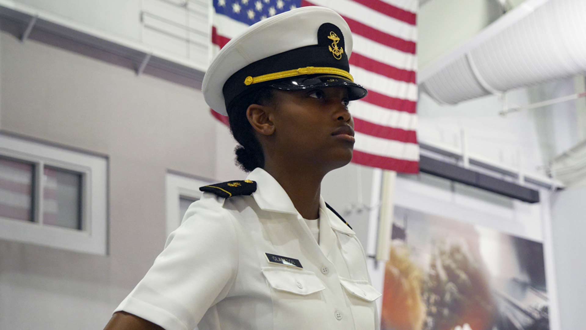 NROTC midshipmen candidates stand in formation at Midway Ceremonial Drill Hall at Recruit Training Command (RTC) during their graduation ceremony. 