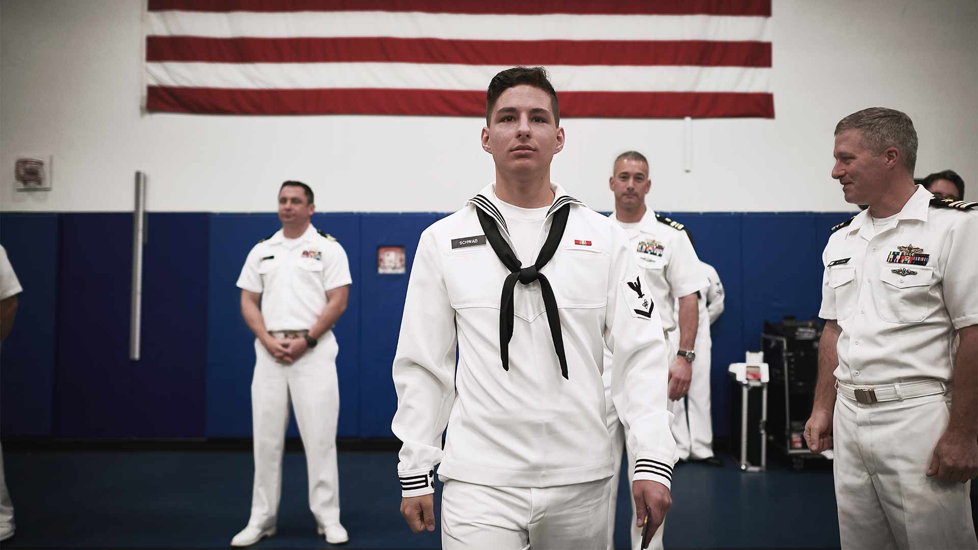 Navy Sailor Thomas Schwab poses in uniform during a graduation ceremony