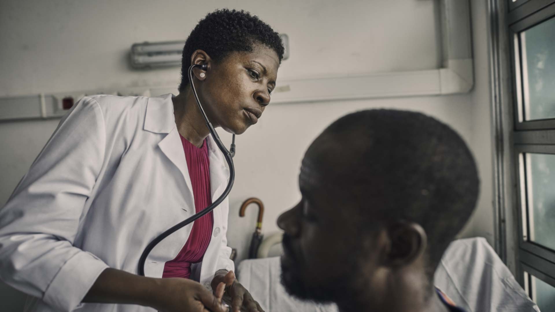us navy sailor and infectious disease phsician doctor nehkonti adams treats a patient at a clinic in monrovia, liberia 