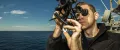 A United States Navy Quartermaster uses a sextant to the measure the angle of the sun on the USS San Jacinto cruiser.
