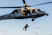 Explosive Ordnance Disposal Technicians fast-rope from an MH-60S Seahawk Helicopter onto the flight deck of USS George Washington.